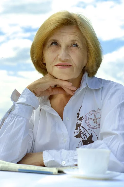 Güzel beyaz yaşlı kadın oturuyor — Stok fotoğraf