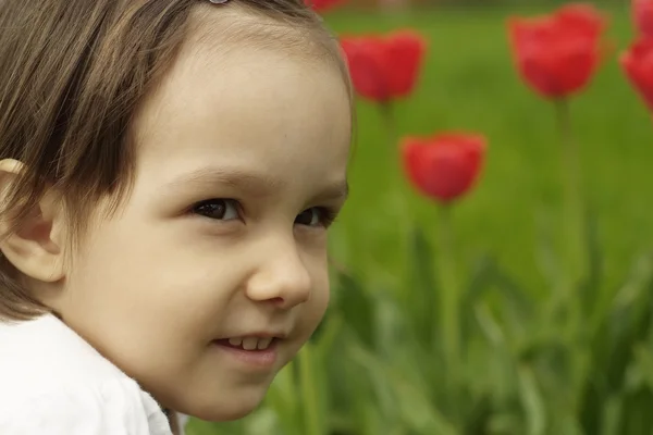 Een mooie Kaukasische baby in bloemen — Stockfoto