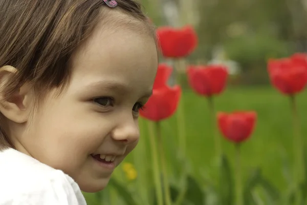 Docela kavkazské dítě v květech — Stock fotografie