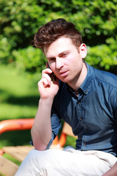 Young man at telephone in nature — Stock Photo, Image