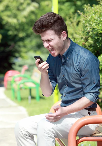 Jovem gritando por telefone no parque — Fotografia de Stock