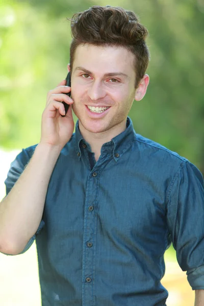 Πορτρέτο του όμορφος άντρας με τηλέφωνο στο πάρκο — Φωτογραφία Αρχείου