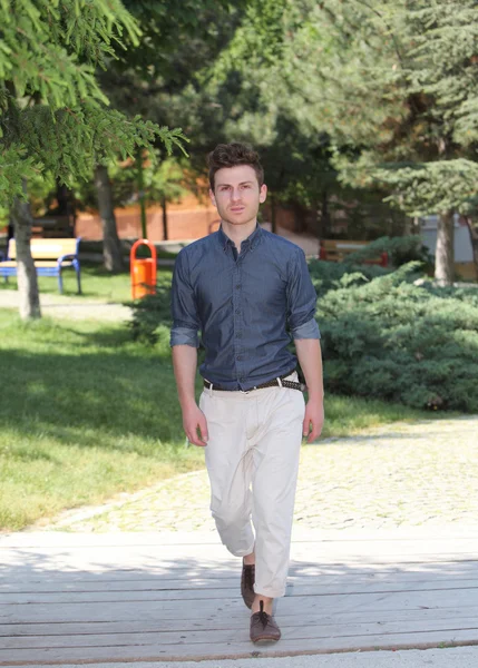 Молодой человек, гуляющий в парке — стоковое фото