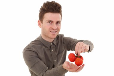 Young man smiling with tomatoes