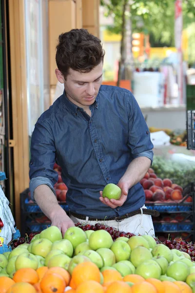 Joven cliente eligiendo frutas en el supermercado — Foto de Stock