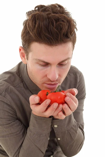 stock image Young man smelling organic tomatoes