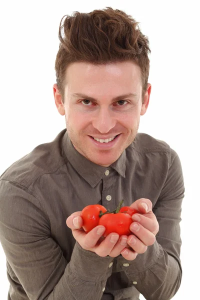 Młody człowiek oferuje pomidory — Zdjęcie stockowe