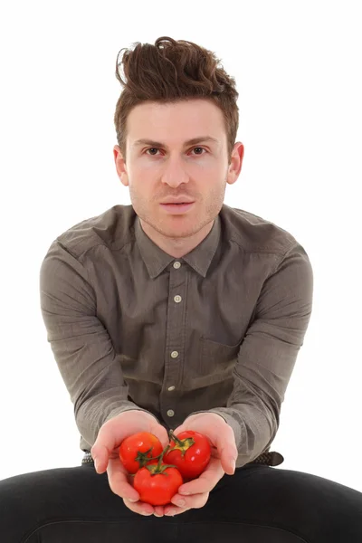 Genç adam domates sunan — Stok fotoğraf