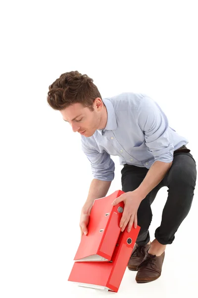 Young employee with falling folders — Stock Photo, Image