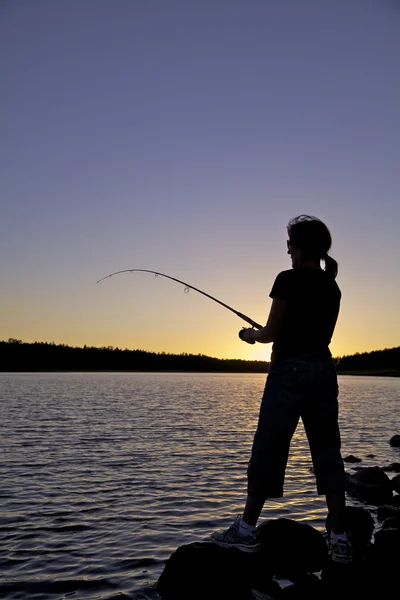 Kvinna fiske vid solnedgången — Stockfoto