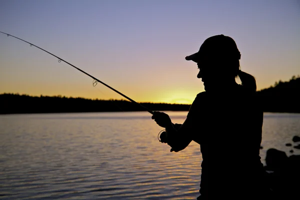 Nő halászati naplementekor — Stock Fotó