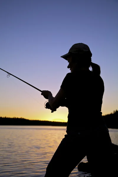 Kvinna fiske vid solnedgången — Stockfoto