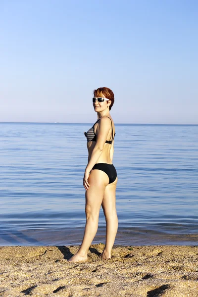 stock image Harmonous woman wearing spectacles sunbathes about the sea