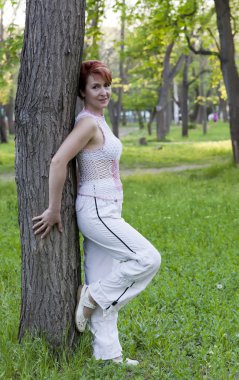 Yaz aylarında bir ağaç yakınındaki harmonous kadın