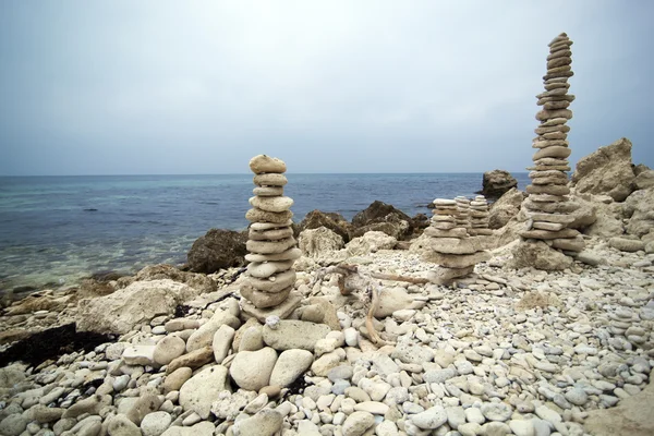Dwie piramidy z kamieni na brzegu morza — Zdjęcie stockowe
