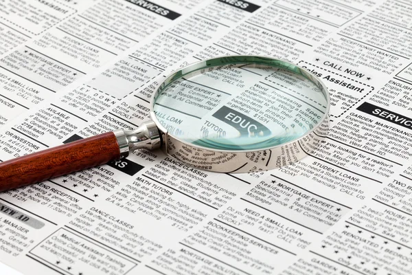 Classified Ad and magnifying glass — Stock Photo, Image