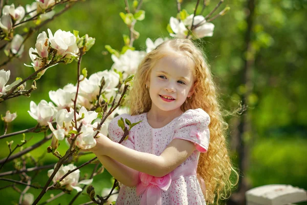 Little beauty and blooming magnolia tree — Stock Photo, Image