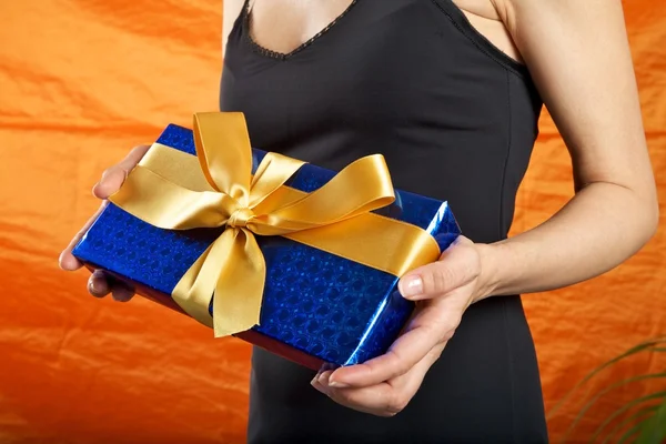 Zwart geklede vrouw blauwe geschenk — Stockfoto
