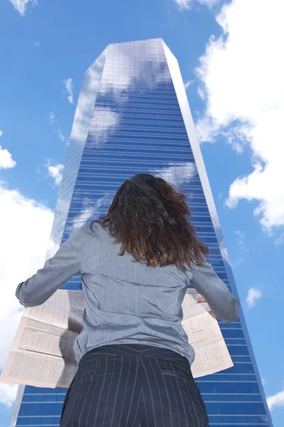 Affärskvinna skyskrapa och tidningen — Stockfoto