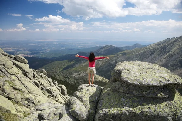 Cross arms woman on sunny rock — Stock Photo, Image