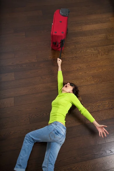 Red suitcase drags a traveler woman — Stockfoto