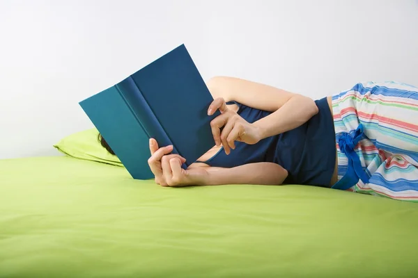 Woman reading on green sheet — Stock Photo, Image