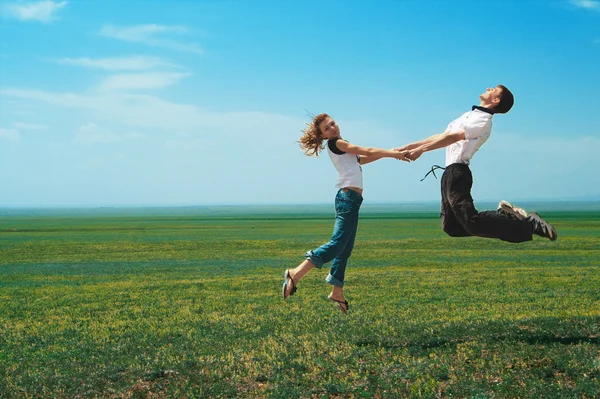 Spaßpaar beim Sprung aufs Feld — Stockfoto
