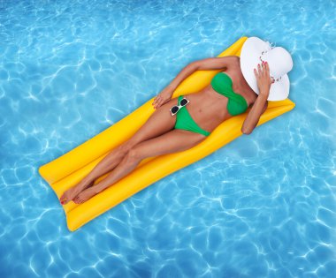Woman relaxing in a pool clipart