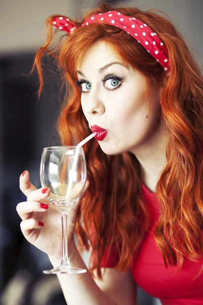 Funny girl drinking wine using straw. — Stock Photo, Image