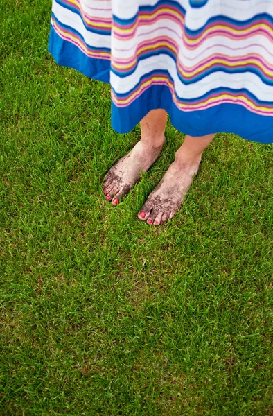 Leriga fötter med röda naglar - trädgårdsarbete koncept — Stockfoto
