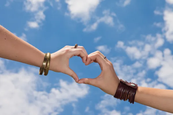 Händer som en hart form på en molnig himmel - kärlek koncept — Stockfoto