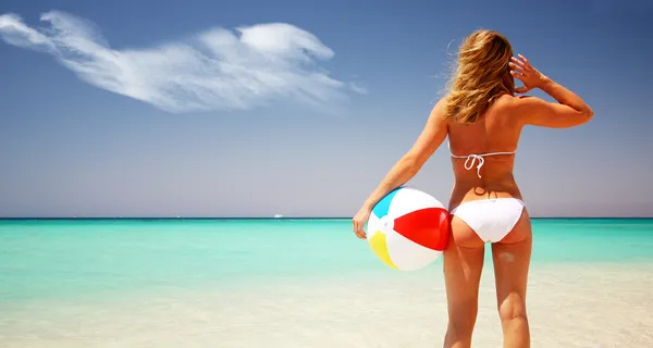 Costas de mulher bronzeada relaxando na praia de areia — Fotografia de Stock
