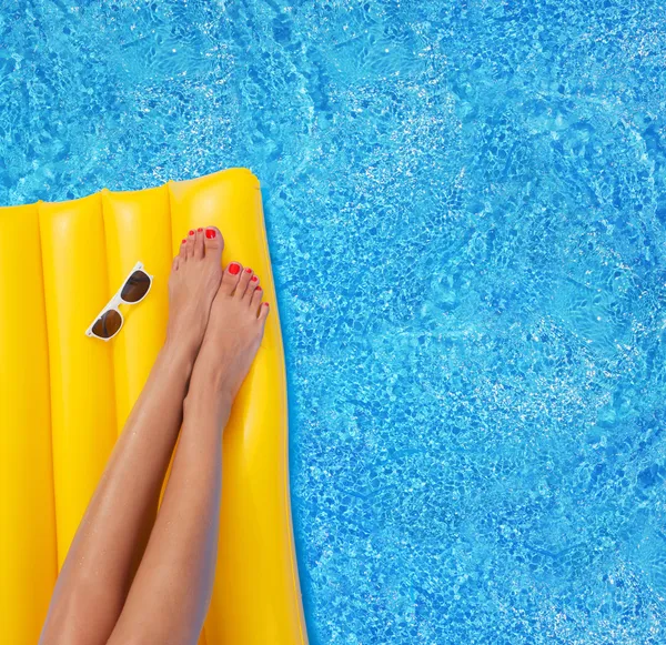 Femme relaxante dans une piscine - pieds fermés — Photo