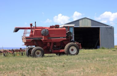 Farm machinery and shed. clipart