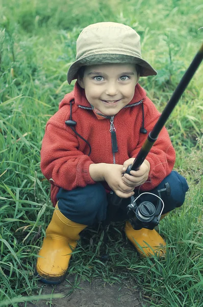 Leende liten pojke håller fiskespö — Stockfoto