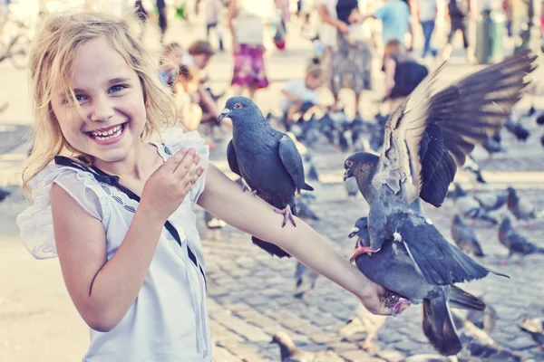 Улыбающаяся девушка с голубями на руке — стоковое фото