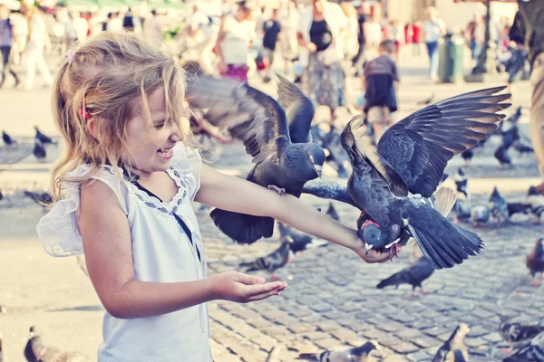 stock image Smiling girl with pigeons on the hand