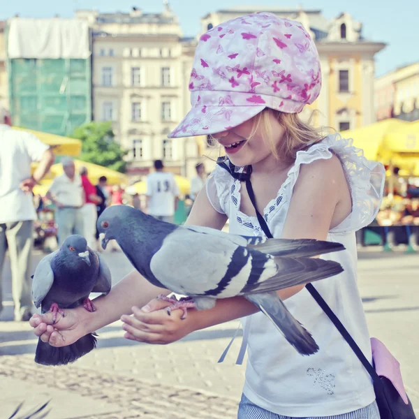 Güvercinler üzerinde el ile gülümseyen kız — Stok fotoğraf