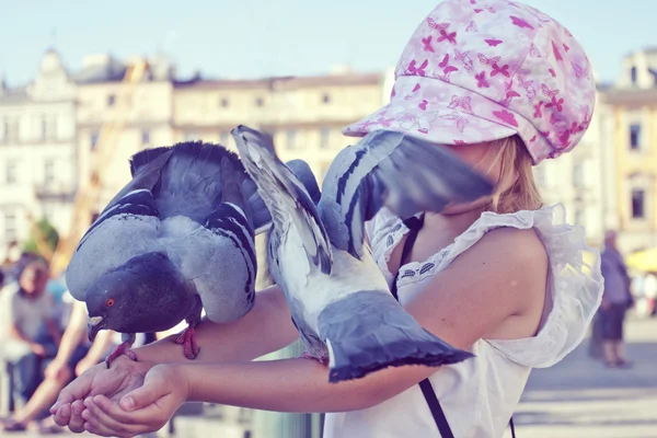 Little girl with pigeons on the arms — Stock Photo, Image