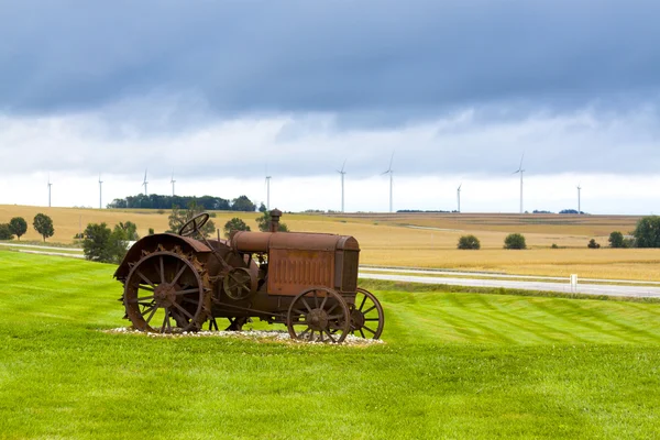 Stary zardzewiały ciągnika z turbin wiatrowych w tle. — Zdjęcie stockowe