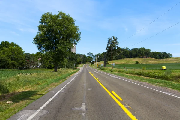 Americká country road s modrou oblohou — Stock fotografie