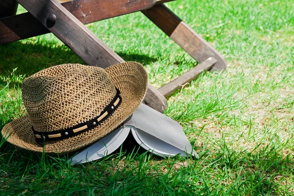 Livro e chapéu de palha na grama — Fotografia de Stock