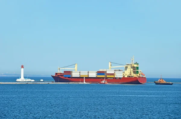 Буксир помогает грузовому судну — стоковое фото