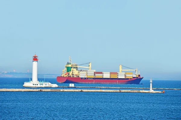 Cargo ship near lighthouse — Stock Photo, Image