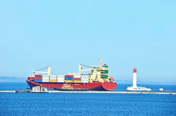 Cargo ship near lighthouse — Stock Photo, Image