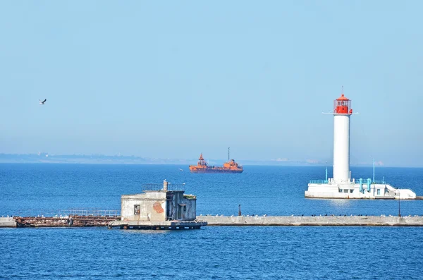 Nákladní loď poblíž lighthouse — Stock fotografie
