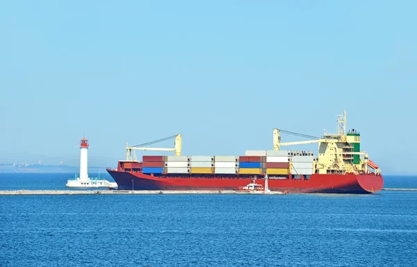 stock image Cargo ship near lighthouse