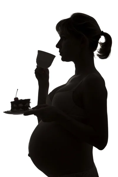 Силуэт беременной женщины с чашкой чая — стоковое фото