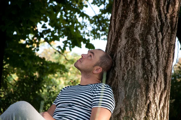 stock image Man sitting under a tree