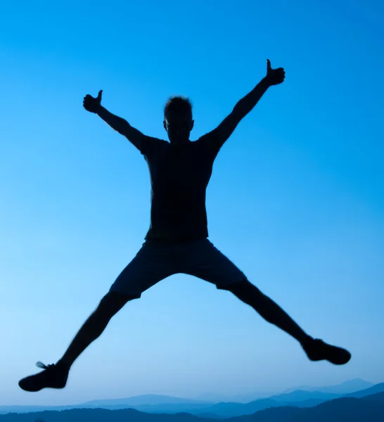 Silhouette of young man who jumps — Stock Photo, Image